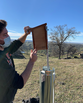 Drew Volpp-Garcia (B.S. in Biology) labeling a violet-green swallow nestbox he just installed