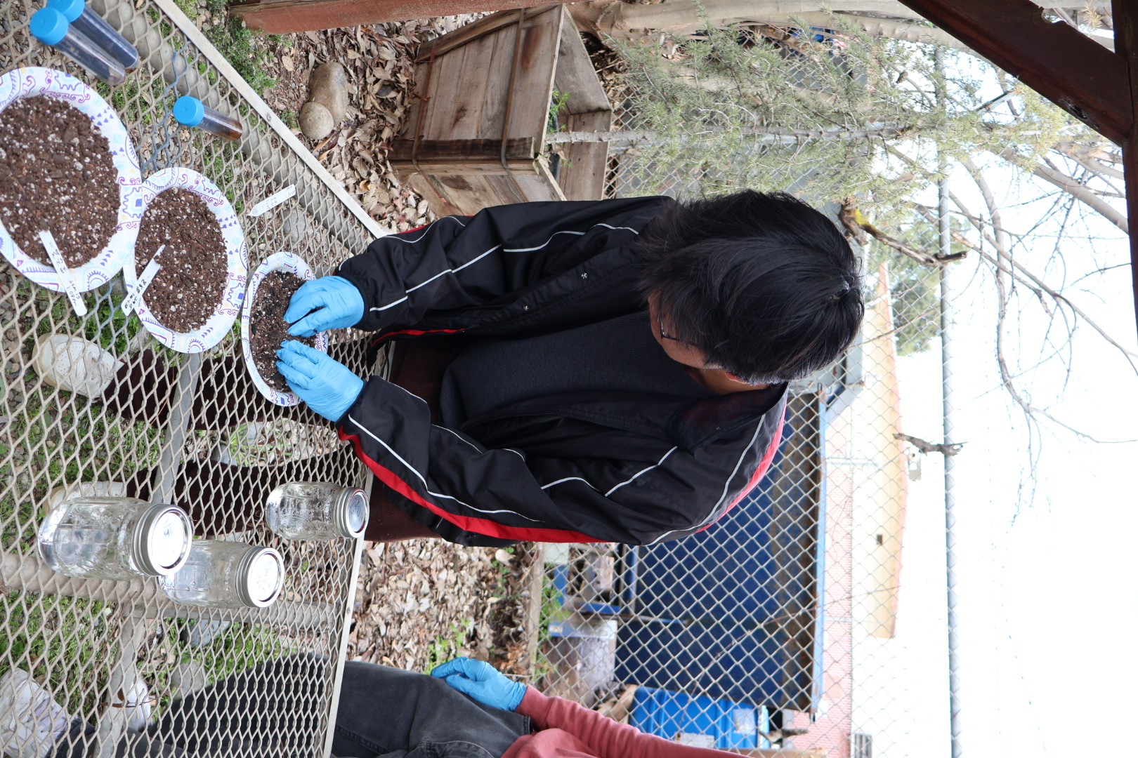 Research student mixing soil by hand. 