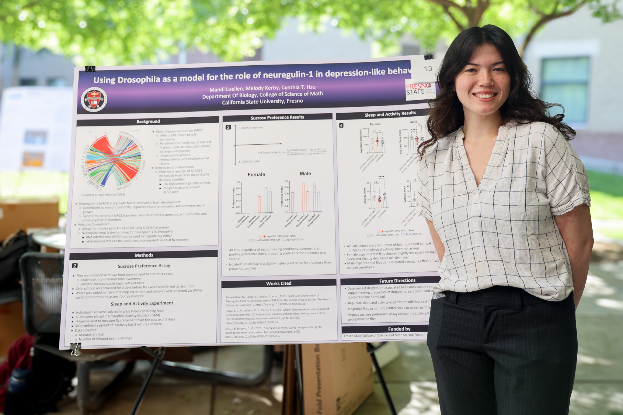 csm culminating experiences presenter standing next to their poster, smiling