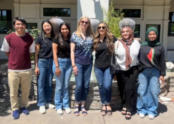 A group of people standing together and smiling at the camera.