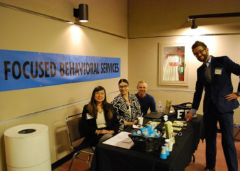 A group of staff tabling an event with informational items available to the public